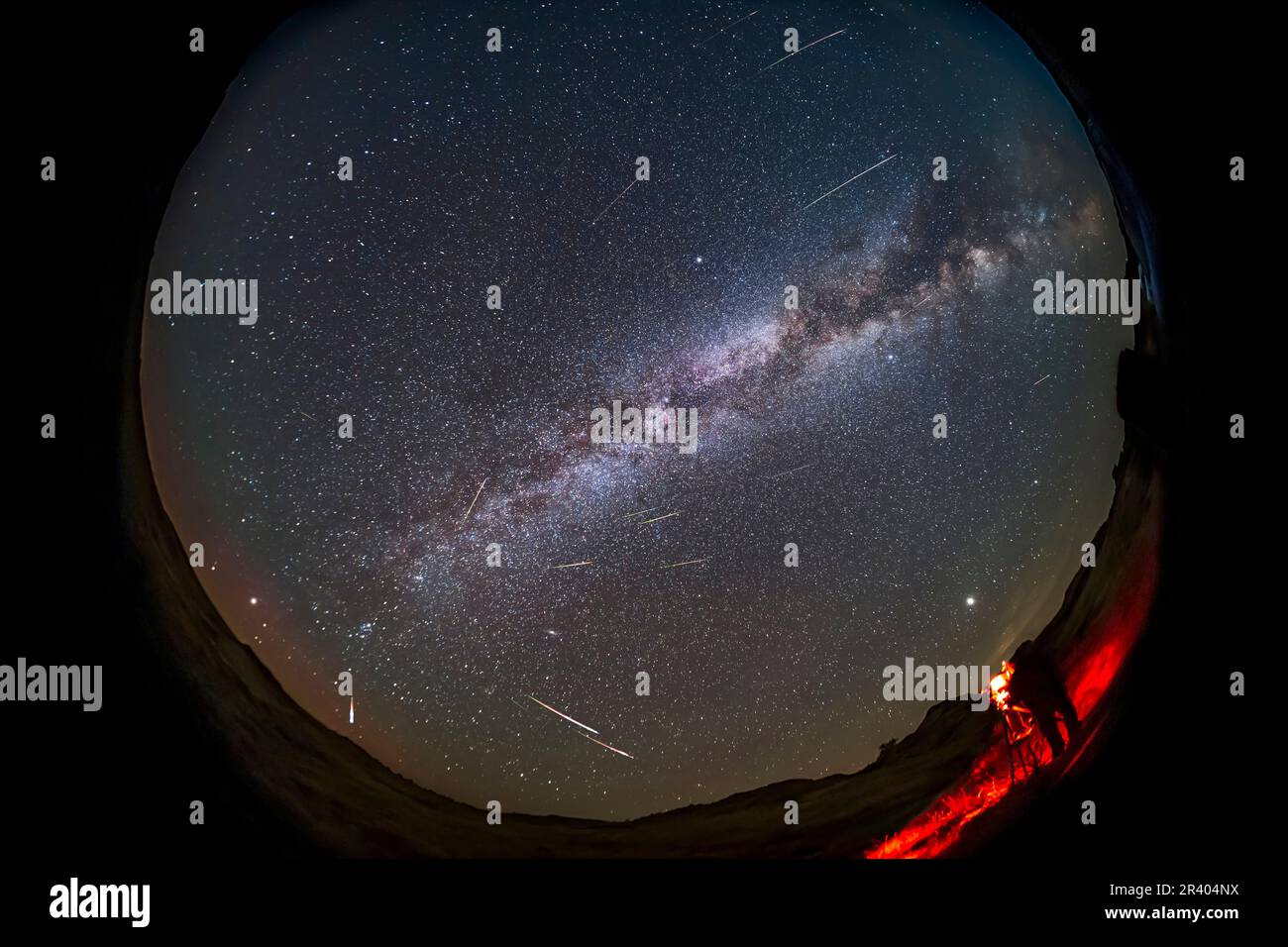 Astronomer photographing the 2021 Perseid meteor shower at Dinosaur Provincial Park, Alberta