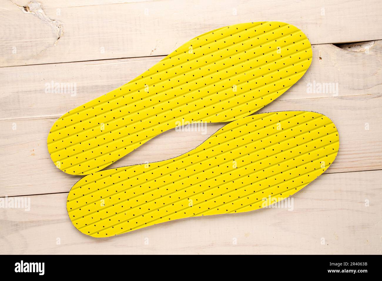 One pair of latex insoles on a wooden table, top view. Stock Photo