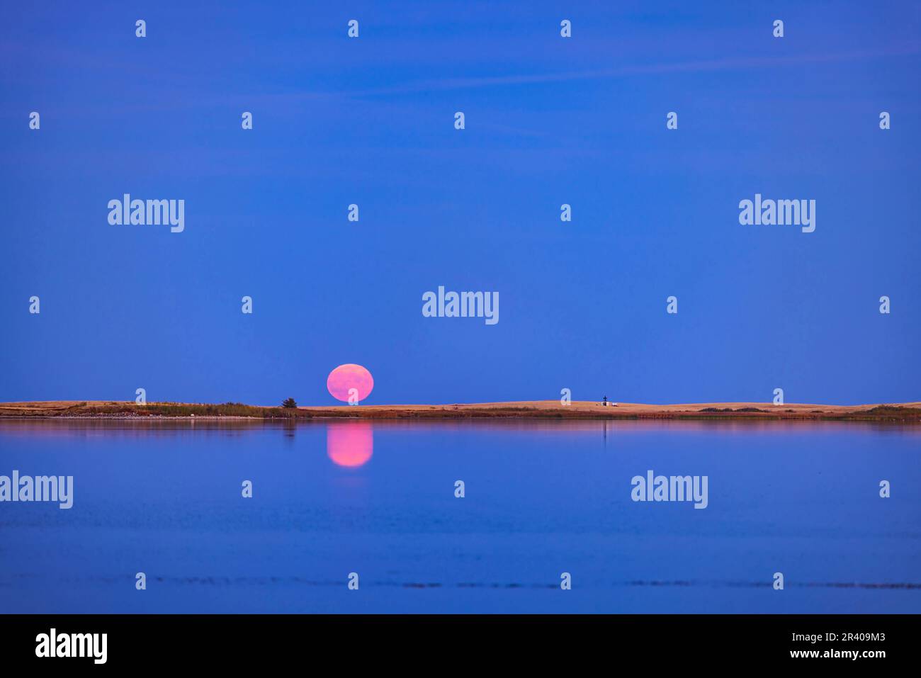 Rising of the full moon reflected over the Crawling Lake Reservoir in southern Alberta, Canada. Stock Photo