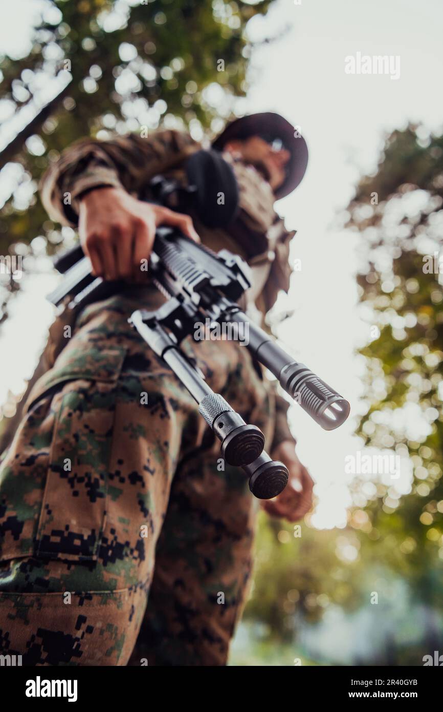 Soldier portrait with protective army tactical gear and weapon having a break and relaxing Stock Photo