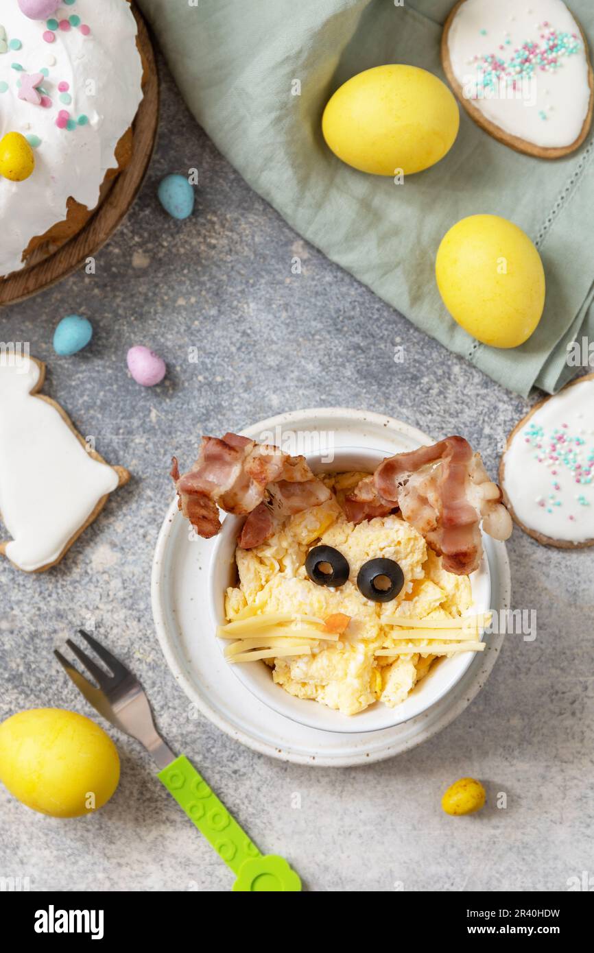 Easter breakfast idea. Scrambled eggs easter bunny on a stone background. View from above. Stock Photo