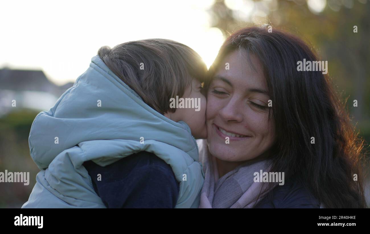 Happy mother and child relationship. Small son kissing mom in cheek