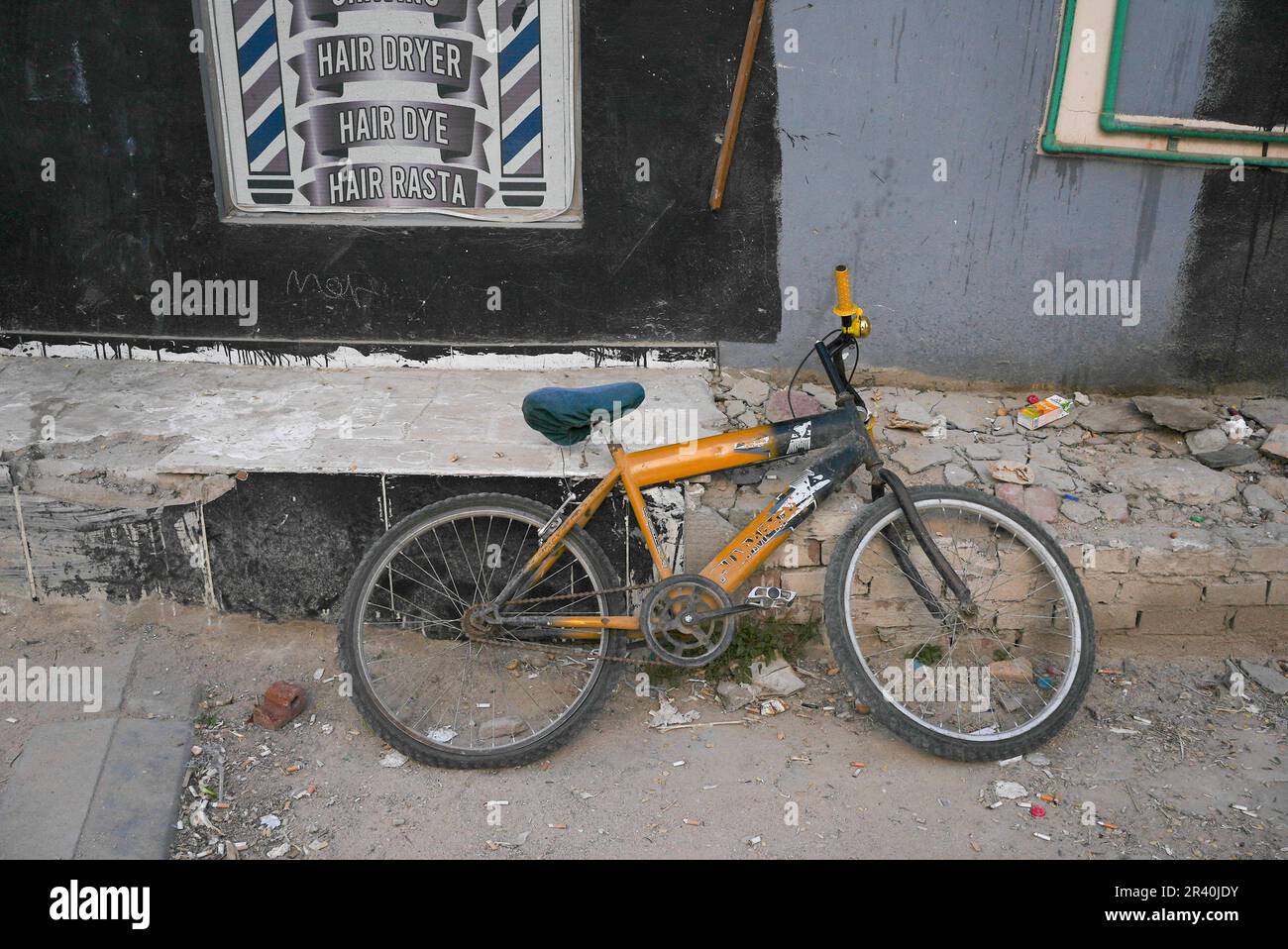 Broken down abandoned bicycle in poor neighbourhood  Stock Photo