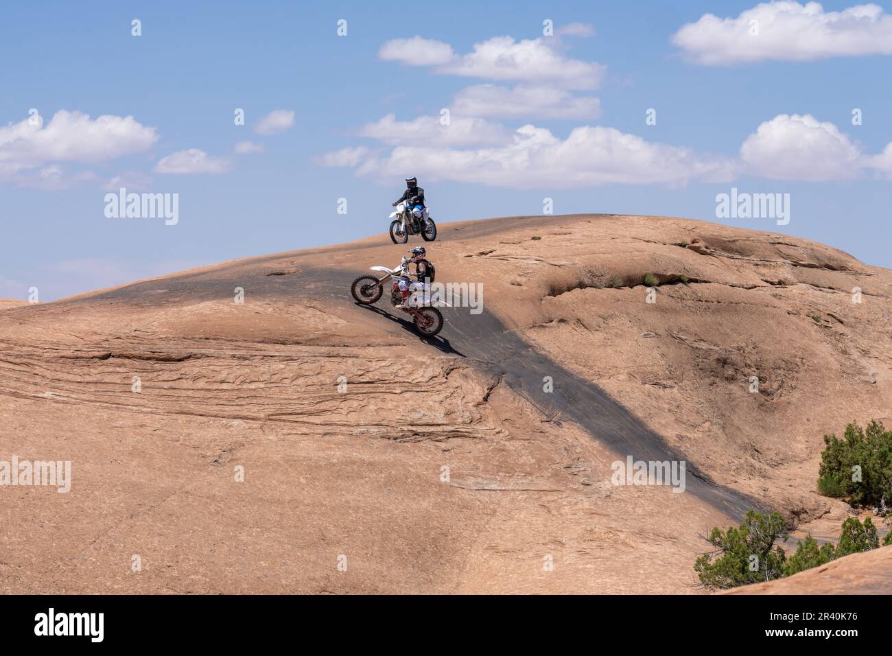Off road motorcycle climbing a steep sandstone dome of the Fins