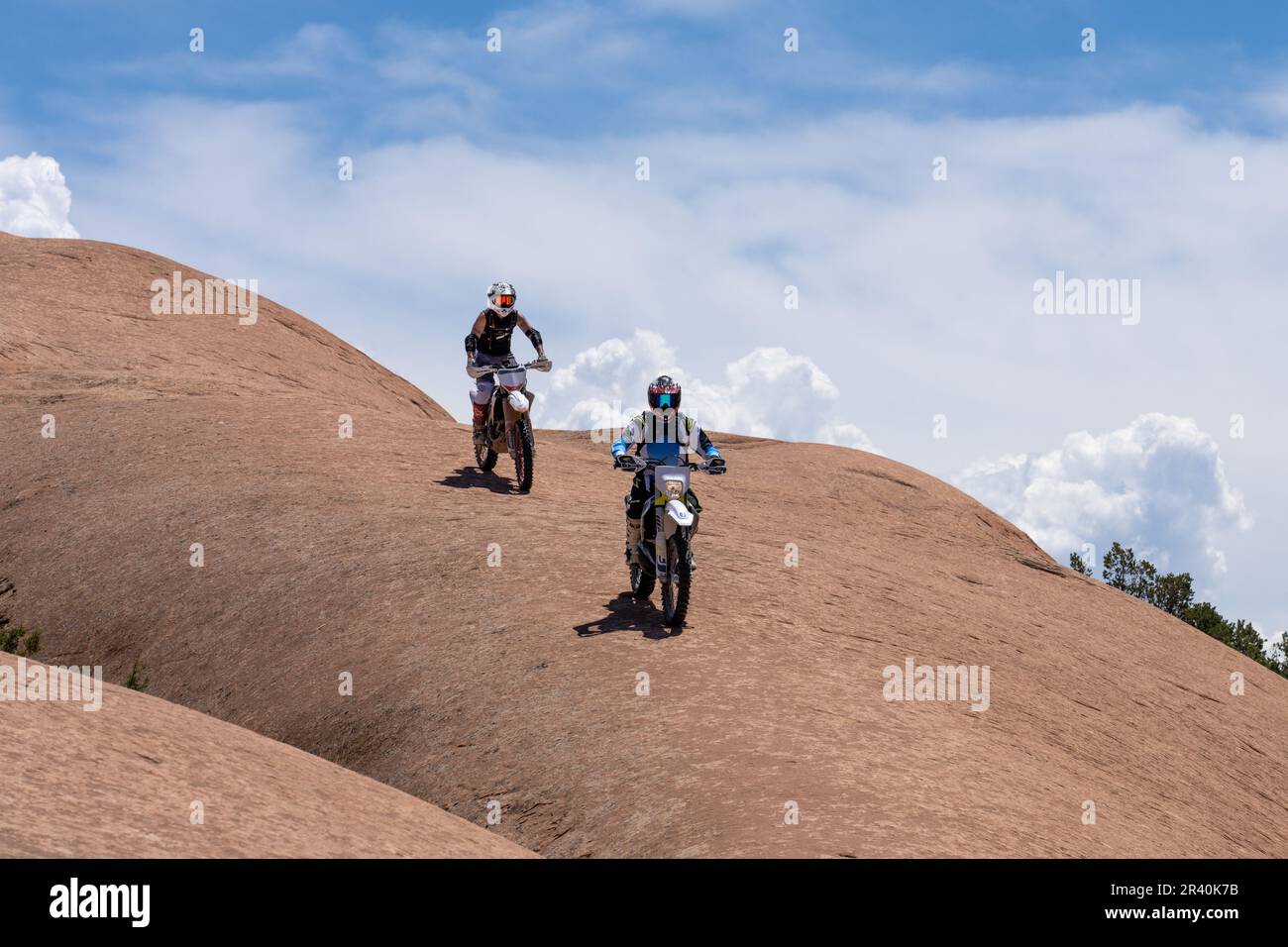 Off road motorcycles riding over the sandstone domes of the Fins