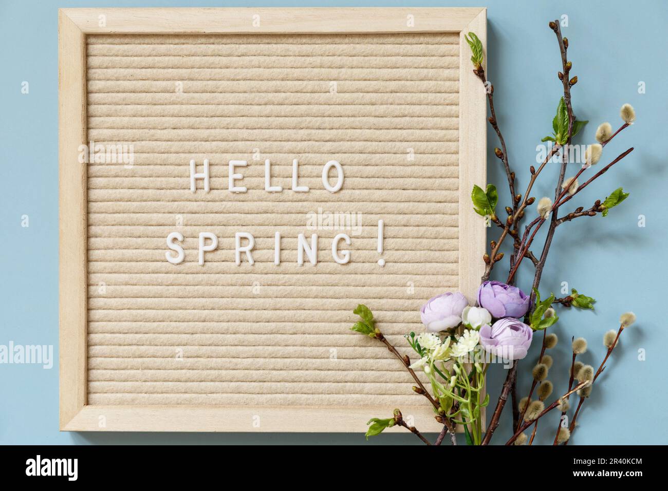 Letter Board with quote HELLO SPRING, with green branches and flowers
