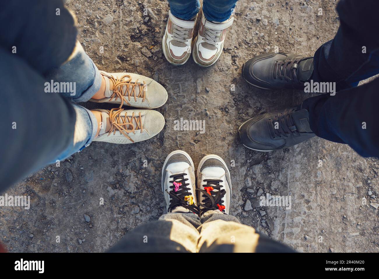 Four pairs of feet of family standing together on ground road. Selfie ...