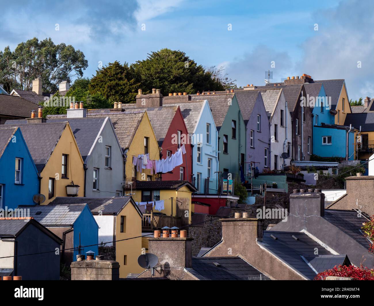 Multicolored European houses along the street of the small Irish town of Cobh, urban landscape. Blue sky over the city. Houses, blue sky Stock Photo