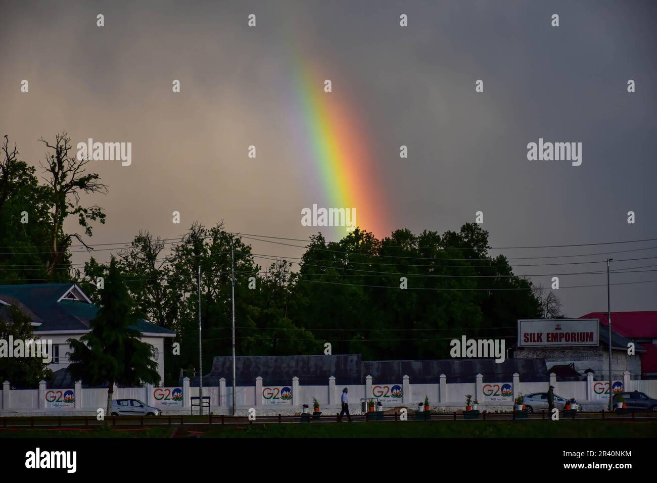 Srinagar, India. 25th May, 2023. A rainbow is seen as residents walk