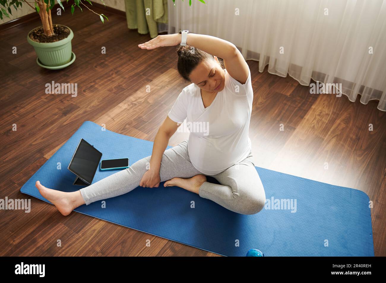 Pregnant woman practicing online pregnancy yoga on a mat, doing prenatal  stretching in body balance exercise. Top view Stock Photo - Alamy