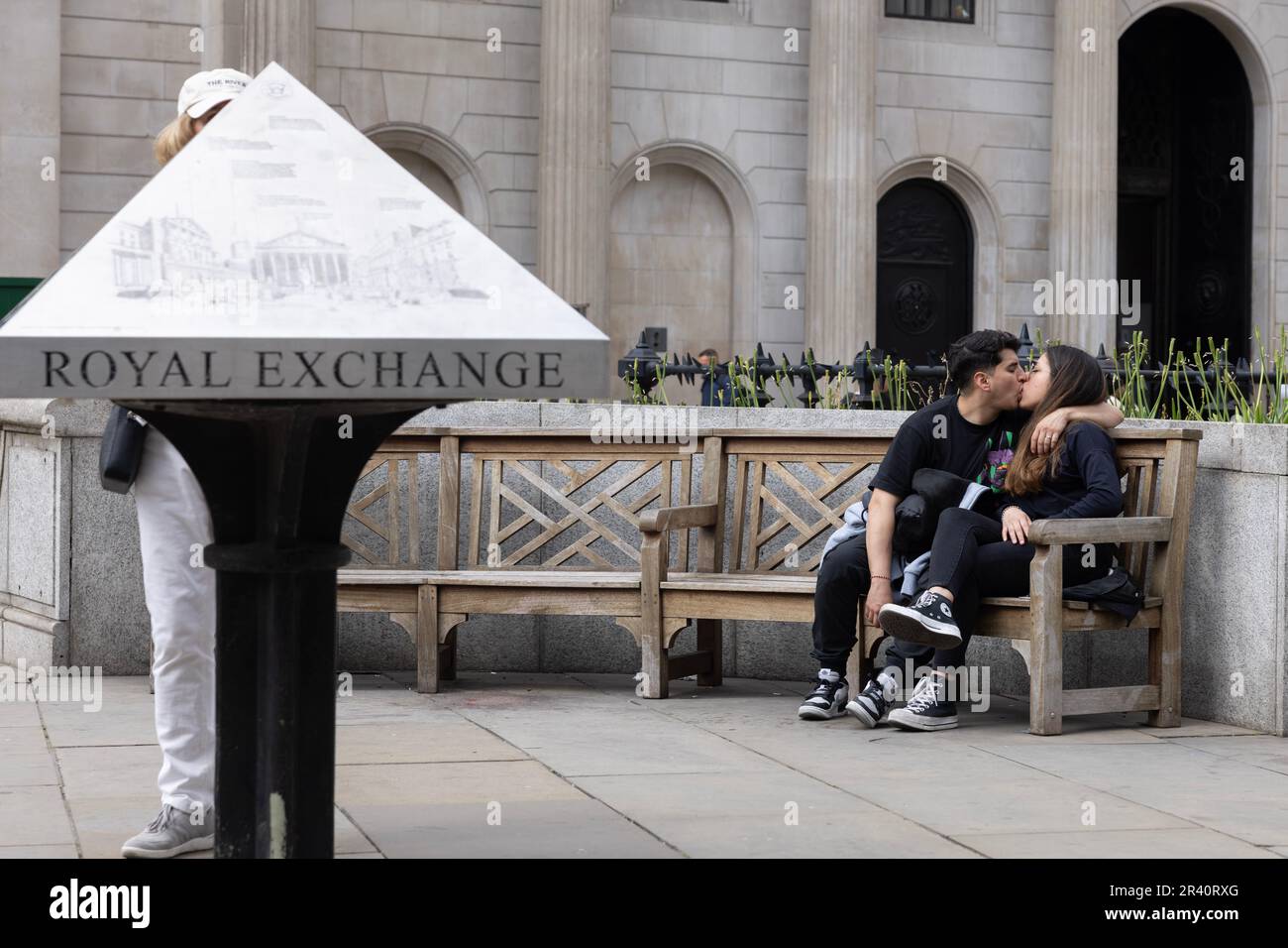 Couple sharing an intimate moment whilst sat outside the Royal Exchange in the heart of the City of London, England, United Kingdom Stock Photo
