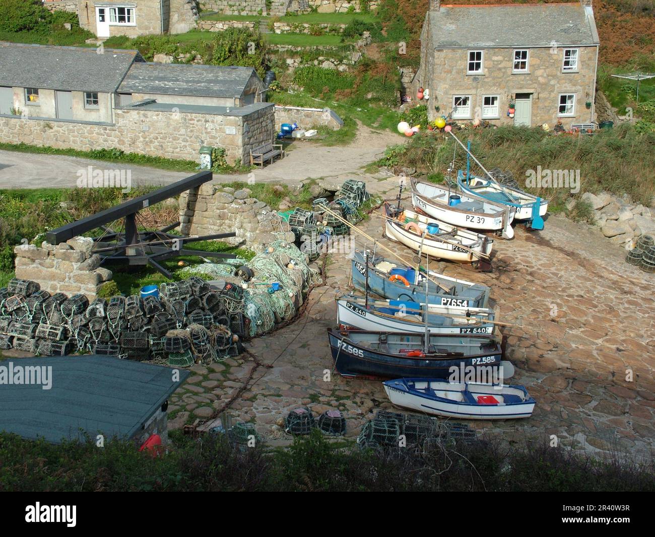 Old capstan boat winch with crab and lobster pots and fishing boats