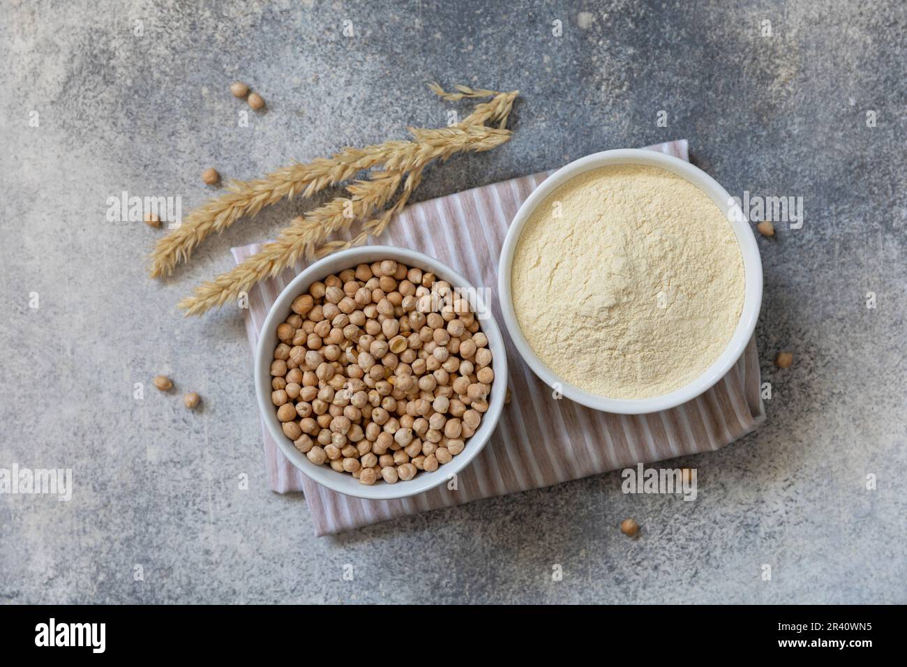 Food and baking gluten-free protein ingredient. Chickpea flour wholesome and raw chickpea over gray stone table. Top view flat l Stock Photo