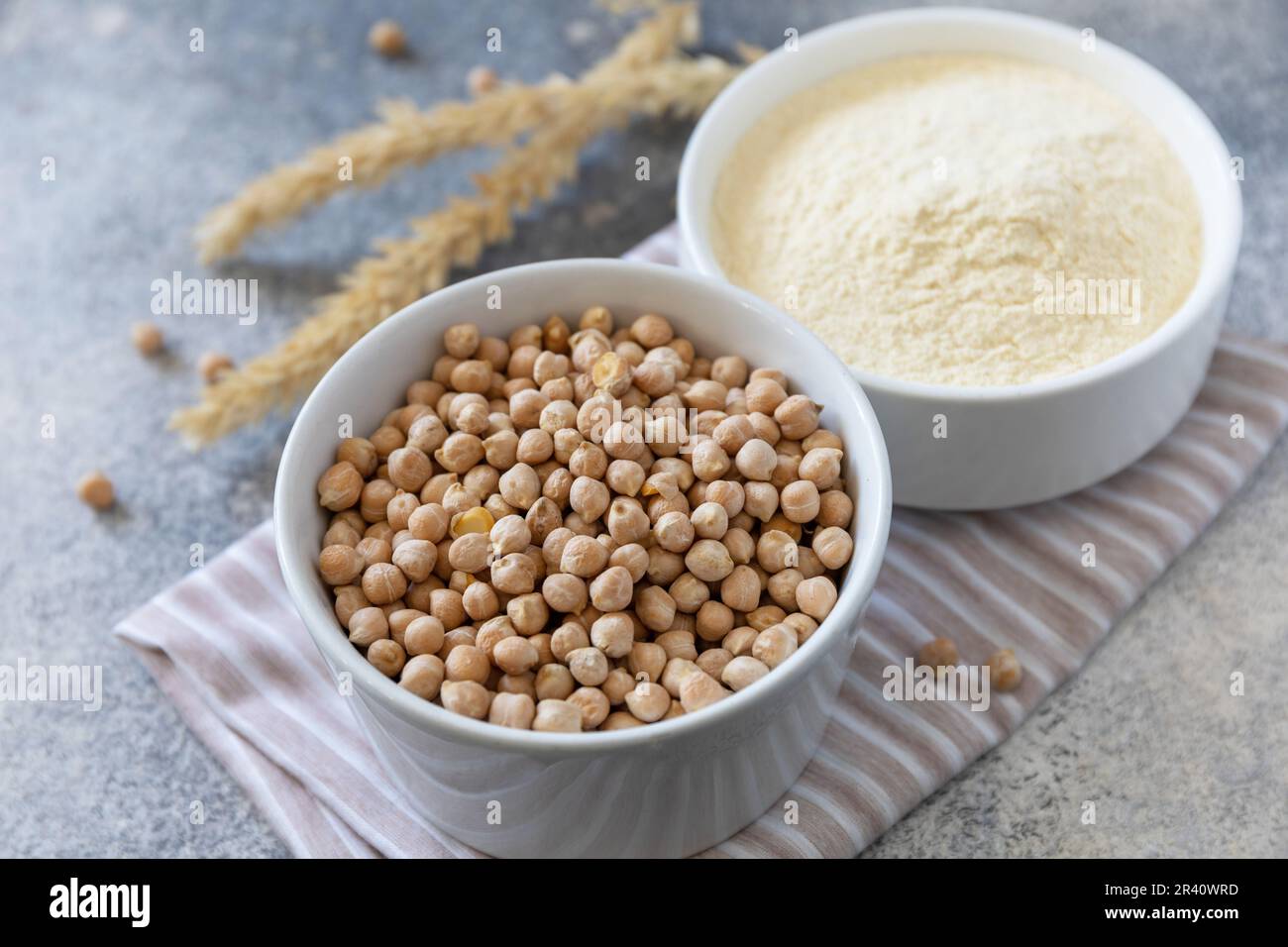 Food and baking gluten-free protein ingredient. Chickpea flour wholesome and raw chickpea over gray stone table. Stock Photo