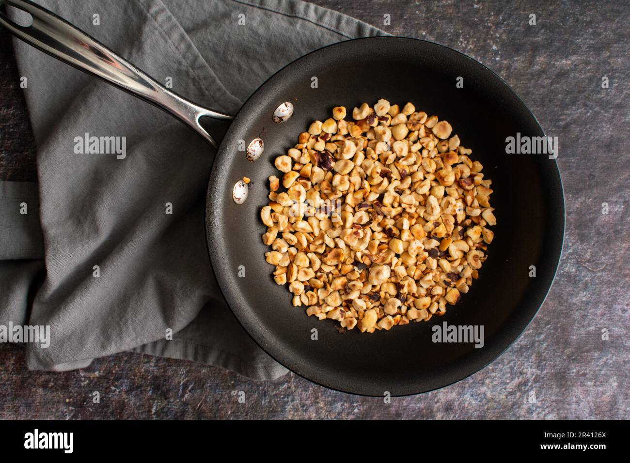Toasted Hazelnuts in a Stainless Steel Measuring Cup Overhead view of