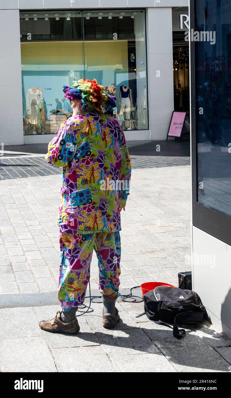 Senior busker in a colourful outfit on Church Street, Liverpool Stock Photo