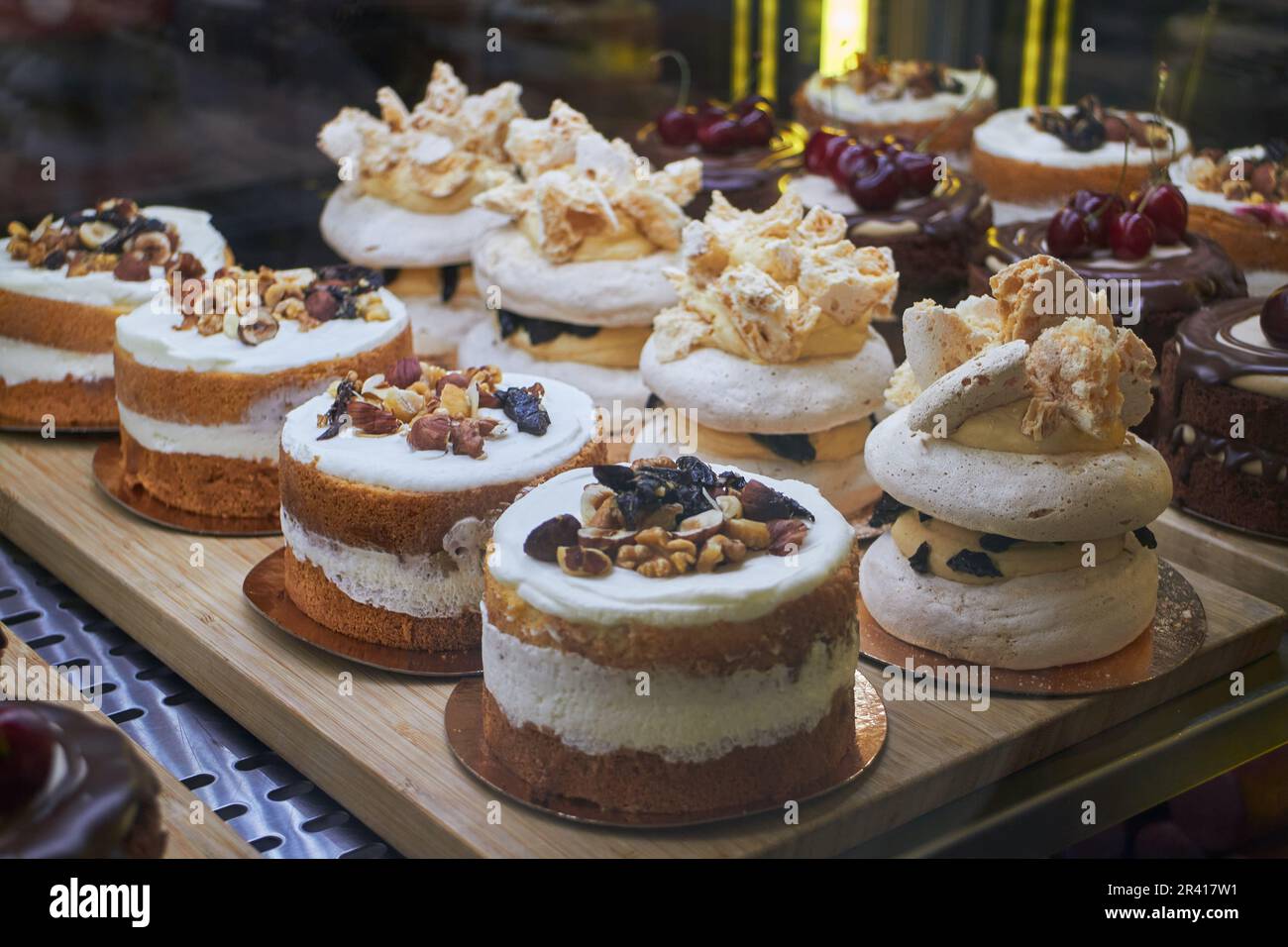 Bento cakes and other desserts with various flavors and decorations in display case for sale in the market. Fashion sweetness. Stock Photo