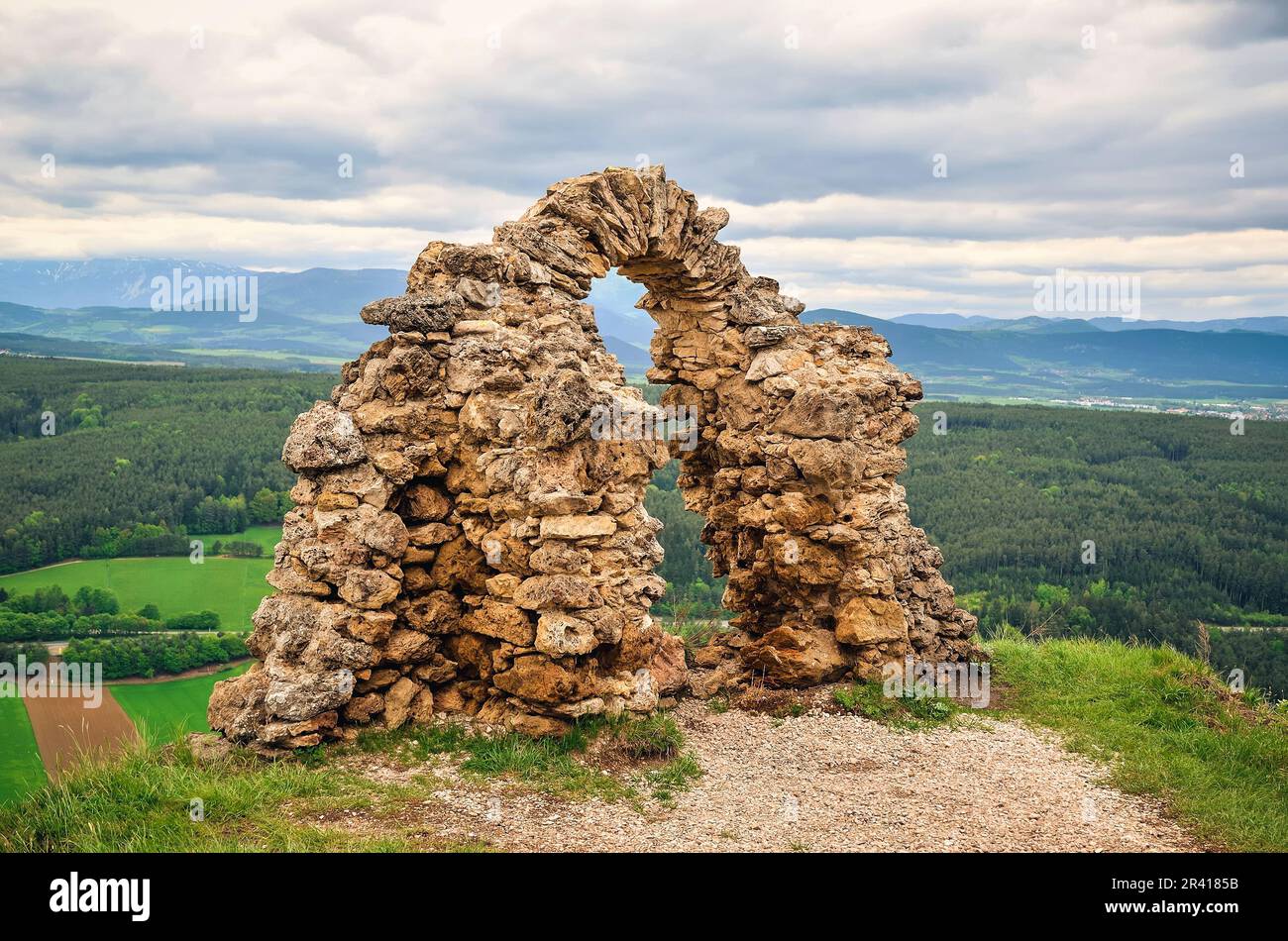 Ancient ruins on a Rockface in Gleissenfeld. Ruins are located in Nature Park Seebenstein-Turkensturz in Austria, with mountains and village in backgr Stock Photo