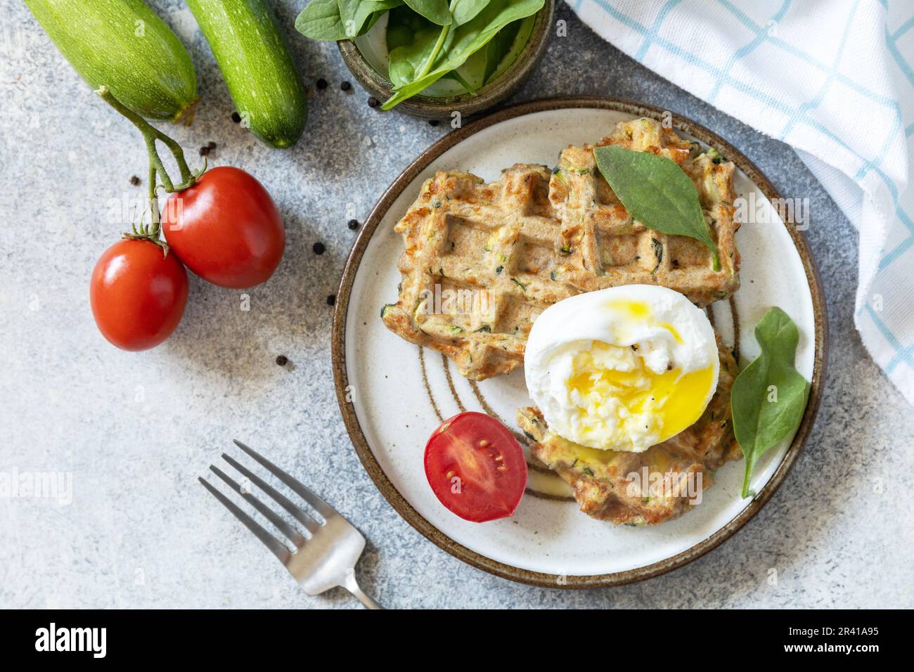Spinach and zucchini vegan waffles with a poached egg on a stone tabletop. The concept of dietary and healthy breakfast. View fr Stock Photo