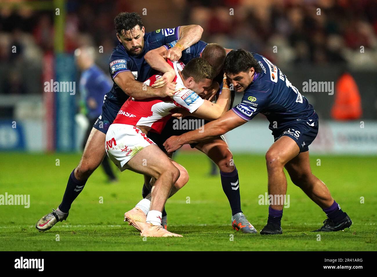 Hull KR's Ethan Ryan (centre) is tackled by Wigan Warriors' Toby King (left), Morgan Smithies and Liam Byrne (right) during the Betfred Super League match at the Sewell Group Craven Park, Hull. Picture date: Thursday May 25, 2023. Stock Photo