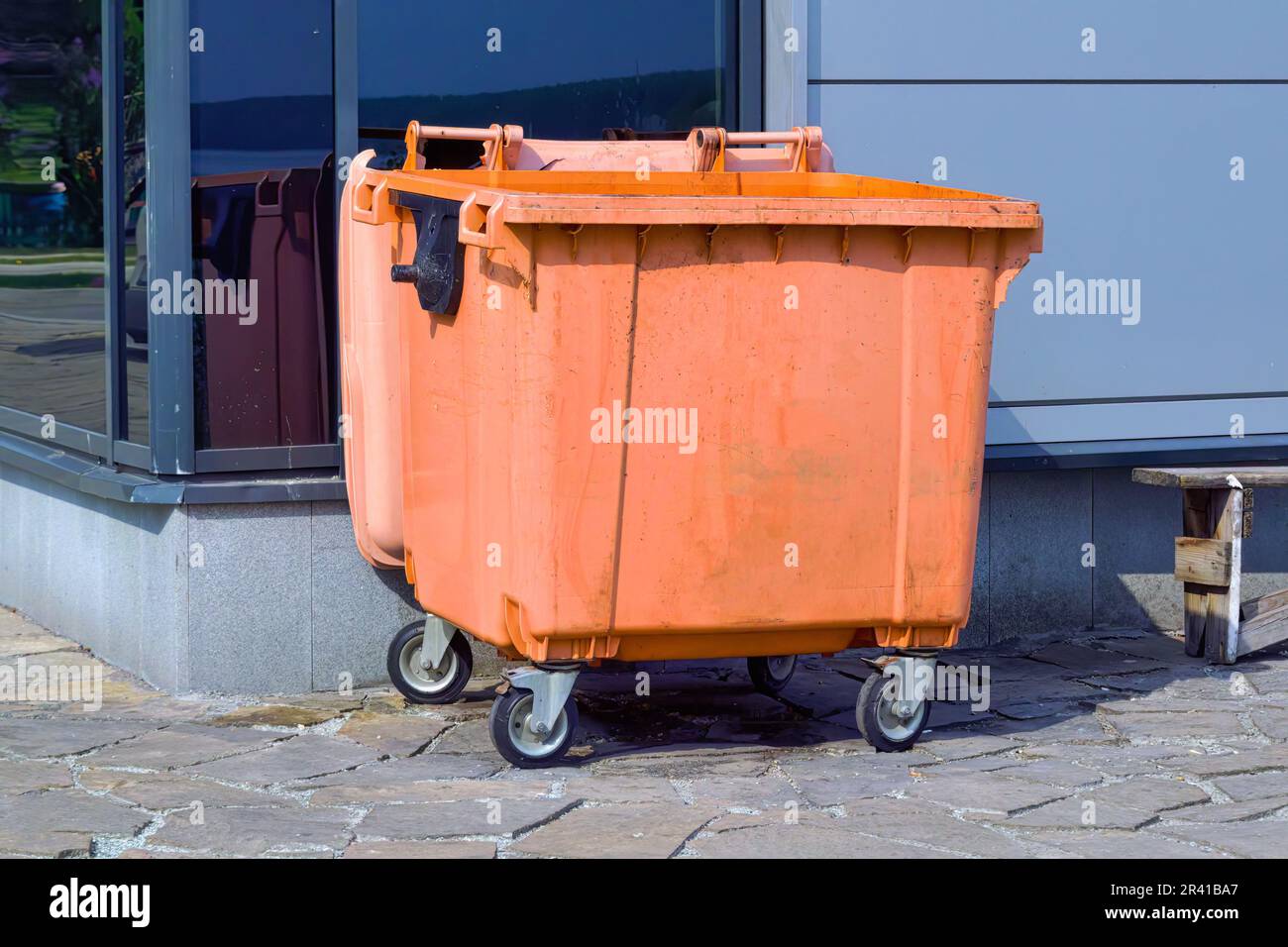 Orange plastic trash recycling container.Orange container for