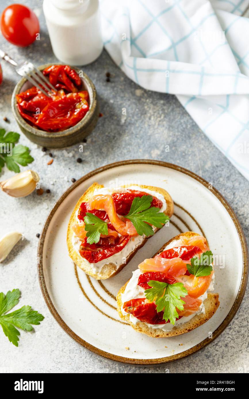 Open sandwiches or bruschetta with salted salmon, cheese and sun dried