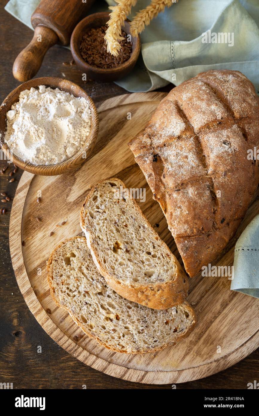 Bread from whole wheat grains, wheat bran, seeds, bio-ingredients over rustic table background. Homemade baking,  healthy lifest Stock Photo