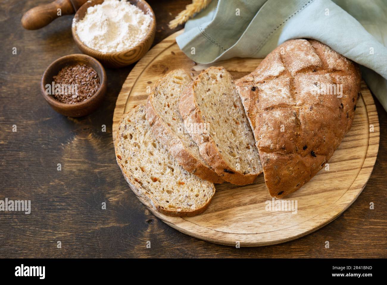 Homemade baking. Bread from whole wheat grains, wheat bran, seeds, bio-ingredients over rustic table background, healthy lifesty Stock Photo