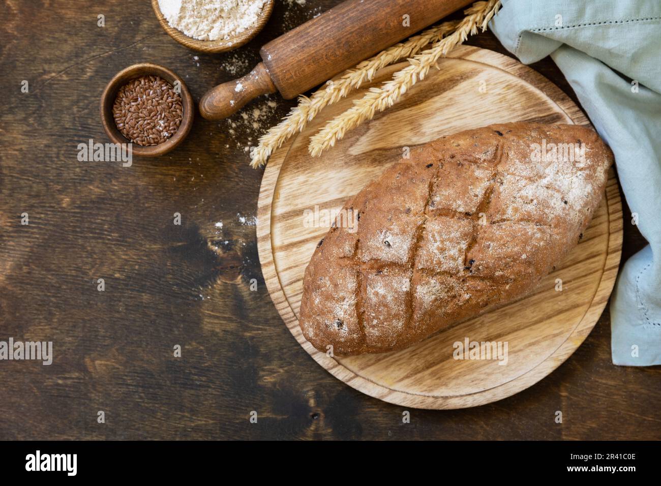 Homemade baking. Bread from whole wheat grains, wheat bran, seeds, bio-ingredients over rustic table background, healthy lifesty Stock Photo