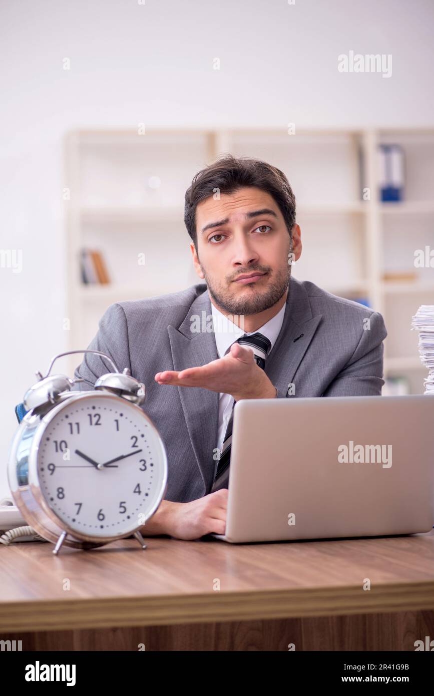 Young employee in time management concept Stock Photo