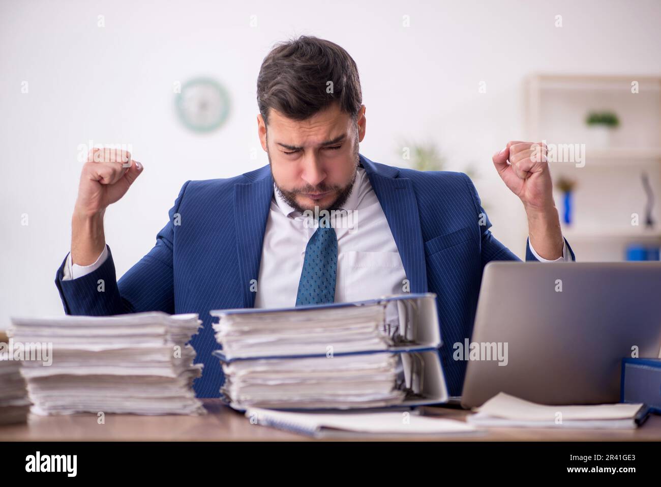 Young businessman employee and too much work in the office Stock Photo