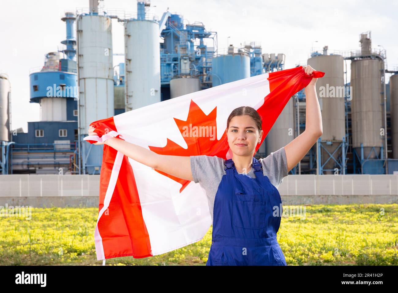 Positive young woman holds the national flag of Canada Stock Photo - Alamy