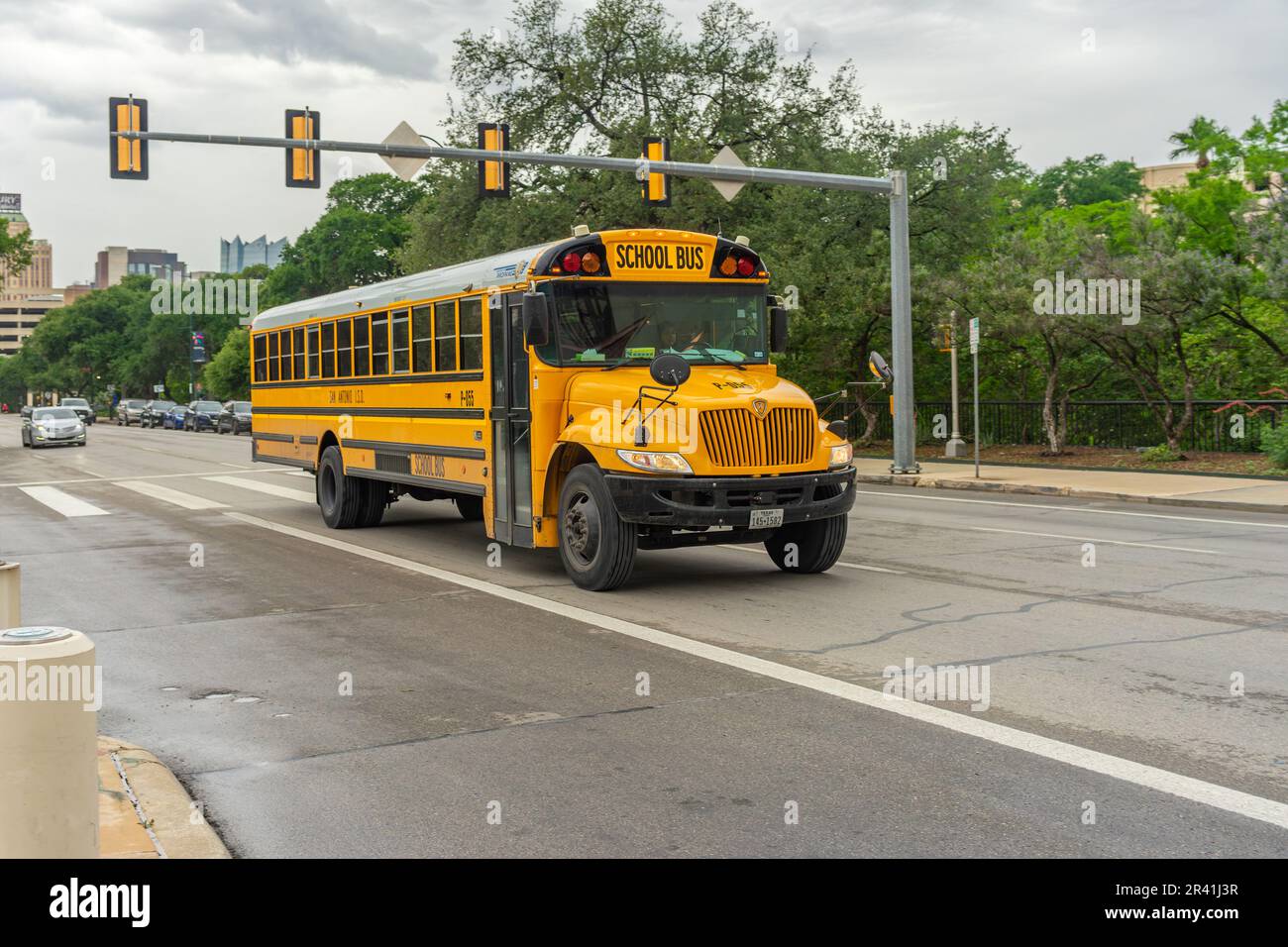 San Antonio, Texas, USA – May 9, 2023: A traditional style school bus traveling on a downtown street in Antonio, Texas. Stock Photo