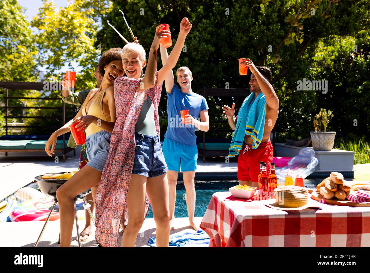 Happy diverse group of friends having pool party, barbecuing and ...