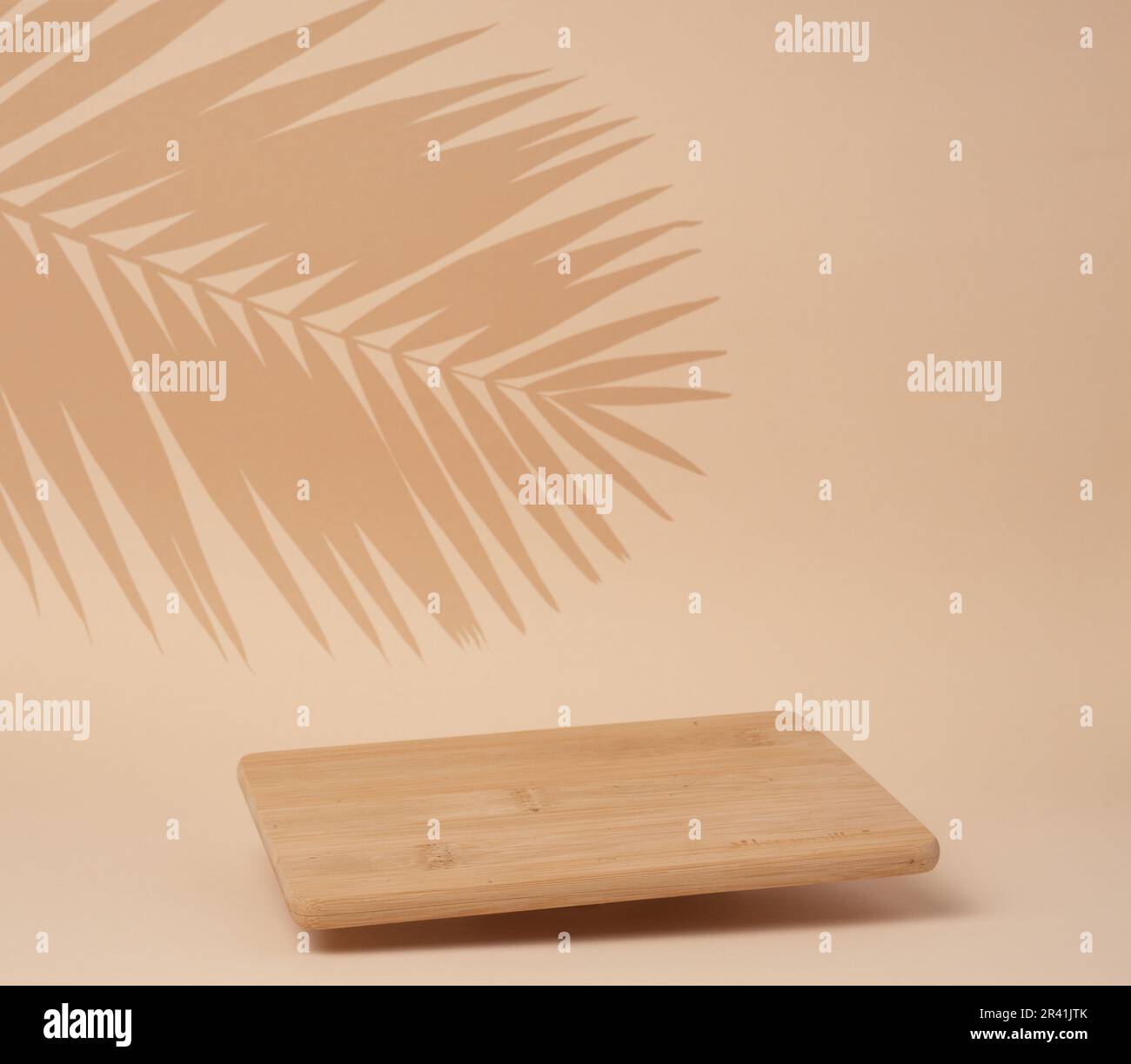 Wooden empty cutting board at an angle on a beige background, kitchen