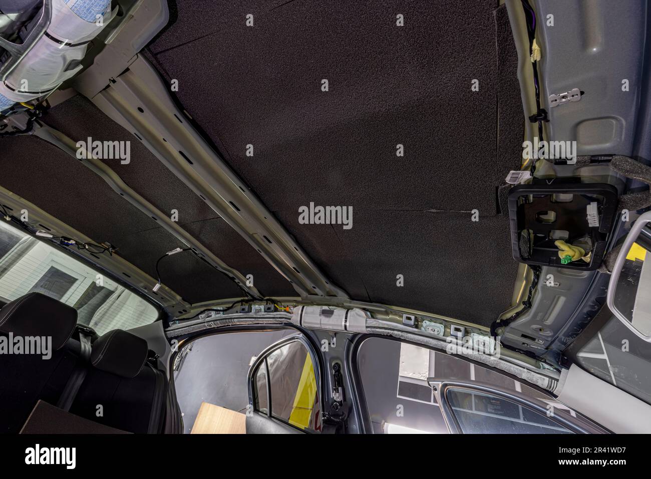 Roll of soundproofing material to car parts. The process of installing the soundproofing of the