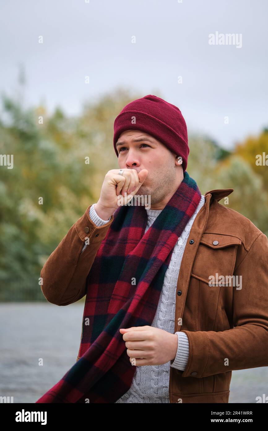 Latin young man coughing over his hand during winter. Cold weather. Flu Stock Photo Alamy