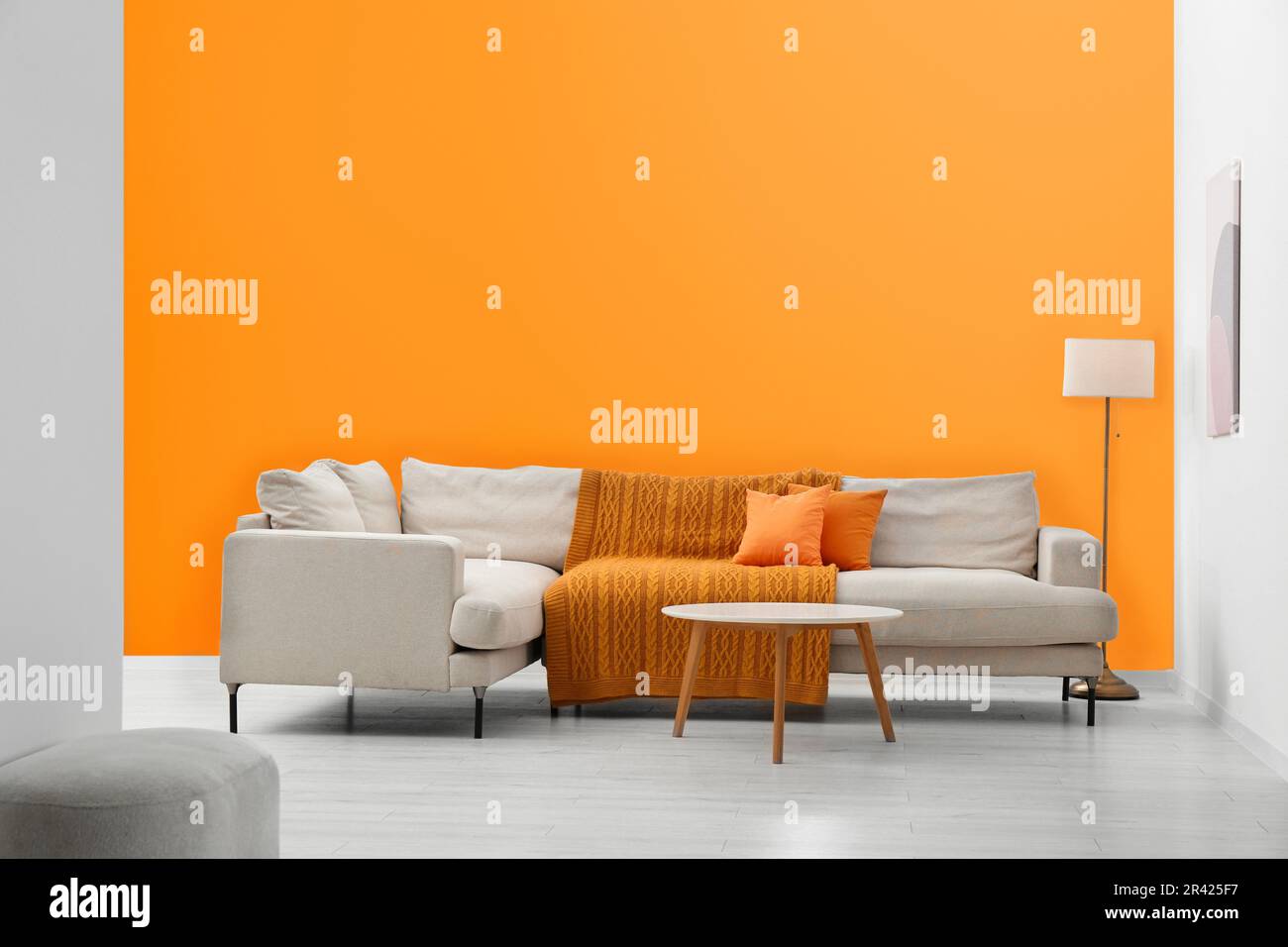 Stylish sofa and coffee table in room with orange walls. Interior ...