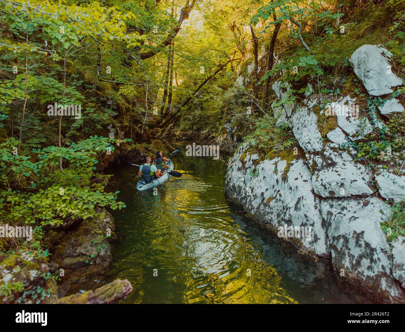 A young couple enjoying an idyllic kayak ride in the middle of a ...