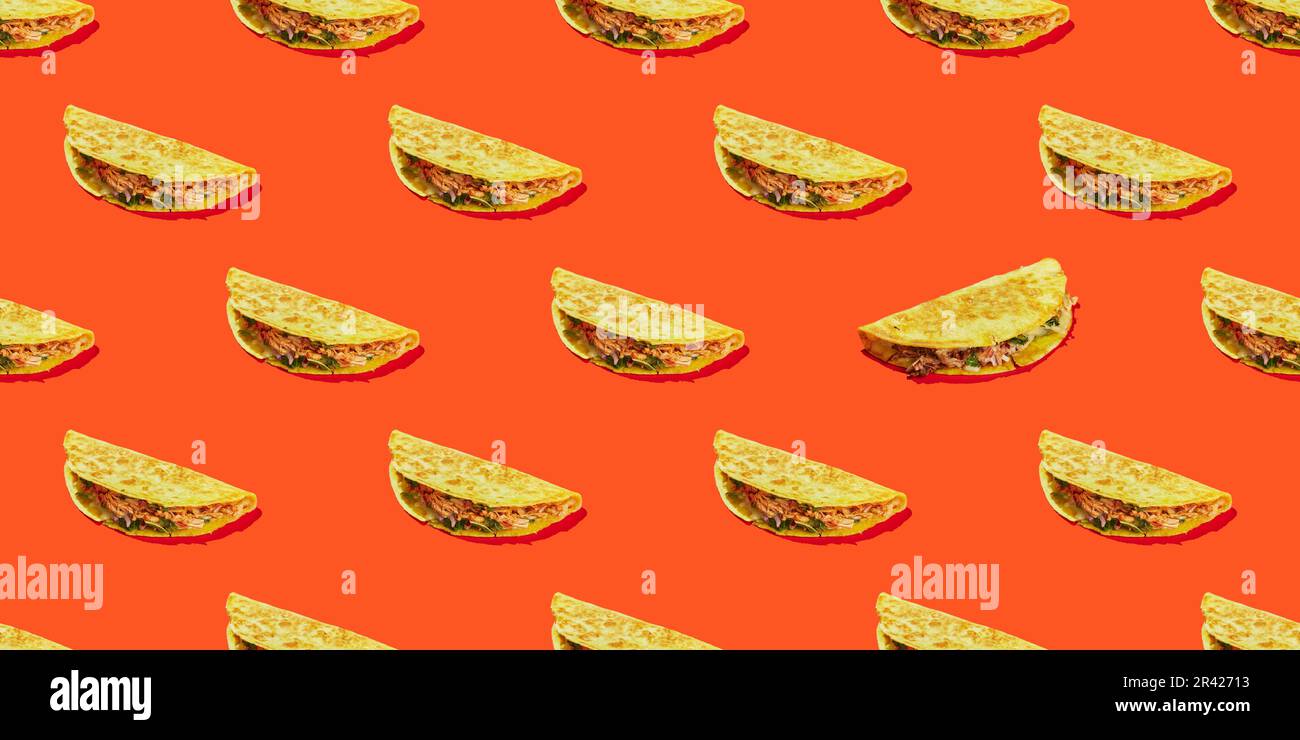 Pattern of corn tortilla tacos stuffed with vegetables and meat on a red background. Traditional Tex-Mex dish Stock Photo