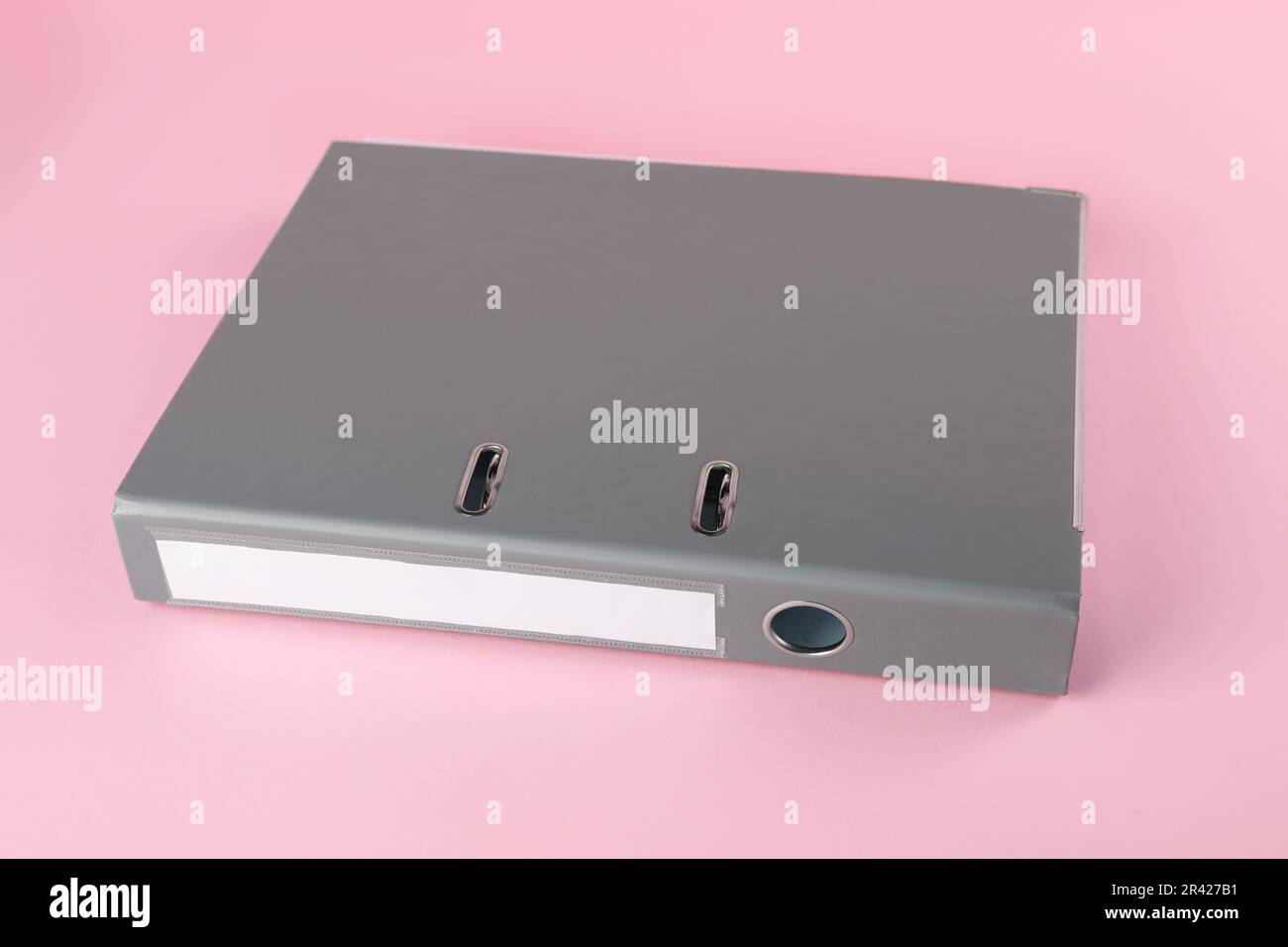 Grey hardcover office folder on pink background Stock Photo