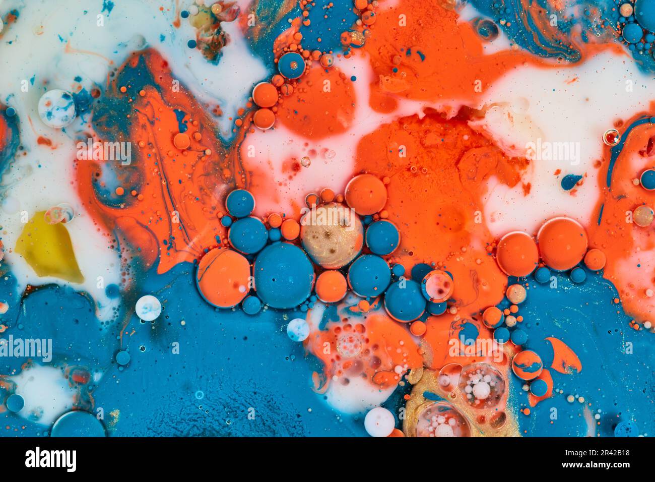 Horizontal acrylic pour creating abstract painting with orange blue and white oil bubbles in milk background asset Stock Photo