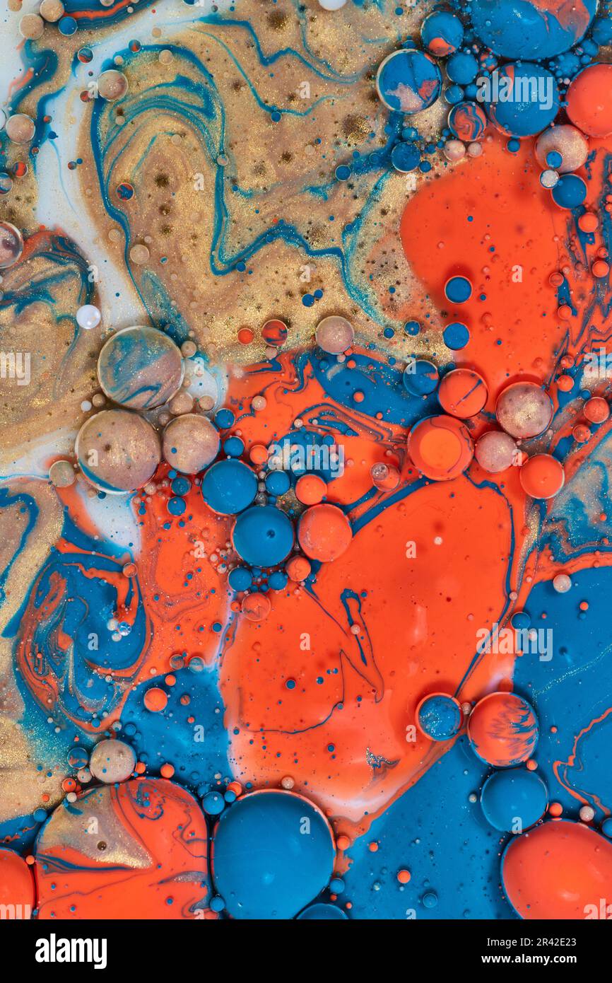 Abstract paint splatter with orange blue orange and white milk in