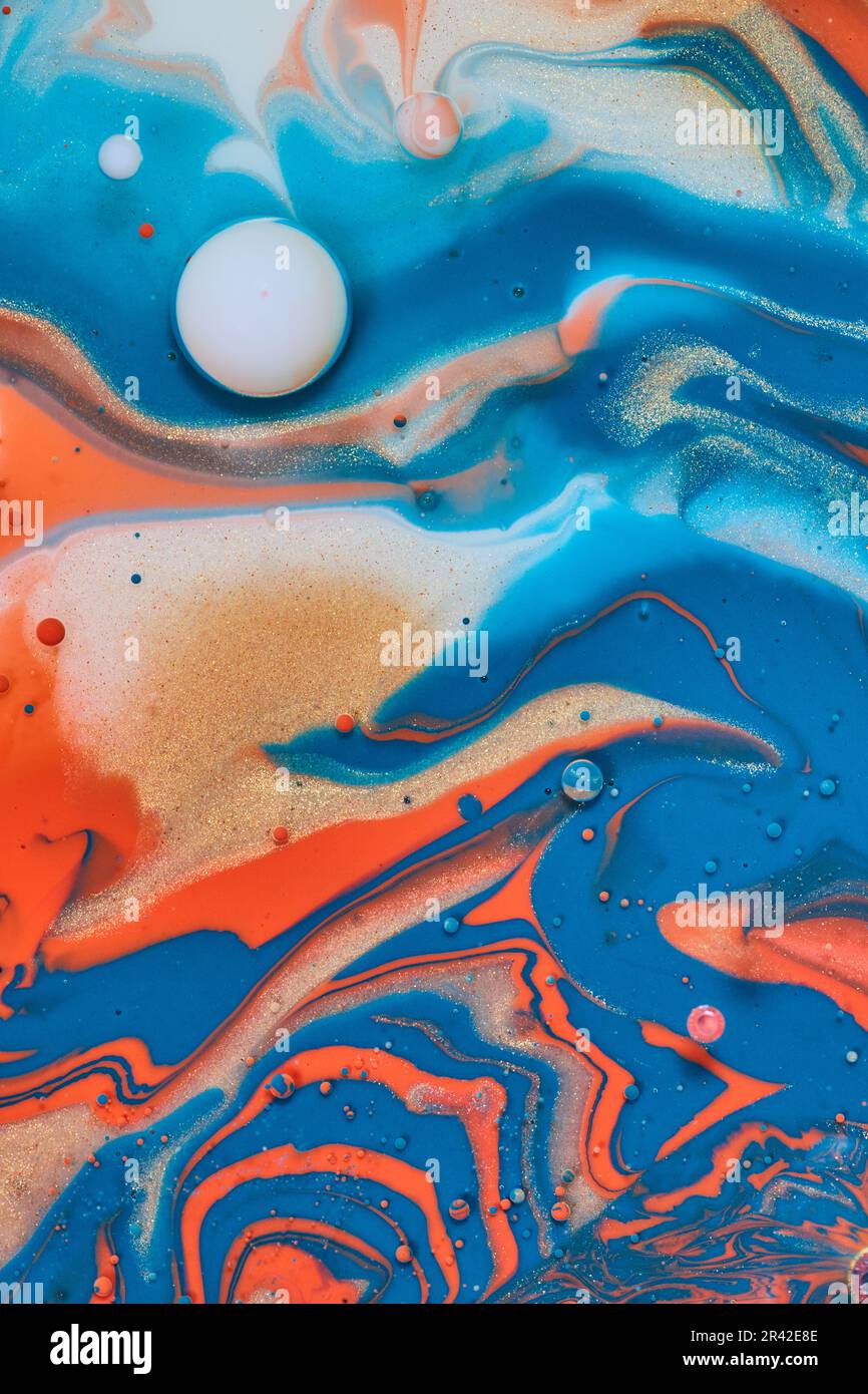 Bubble of white in sea of acrylic paint with blue orange and gold