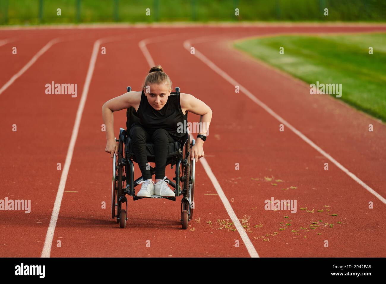 A woman with disablity driving a wheelchair on a track while preparing ...