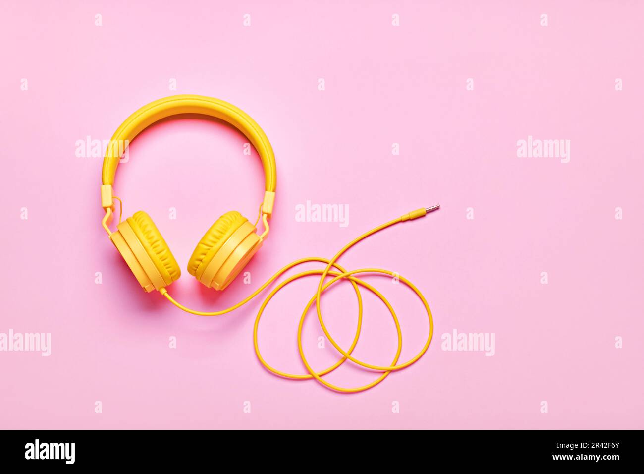 Yellow headphones on pink background. Minimal Music concept, flat lay, copy space Stock Photo