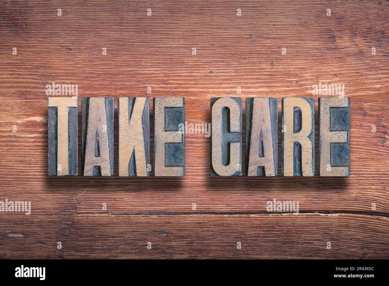 take care phrase combined on vintage varnished wooden surface Stock Photo