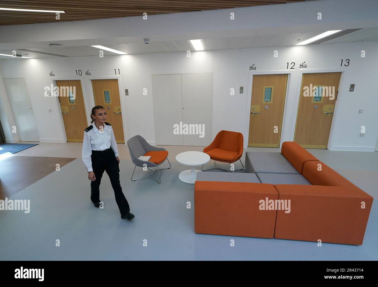 A prison officers walks passed rooms within Iris House as Justice