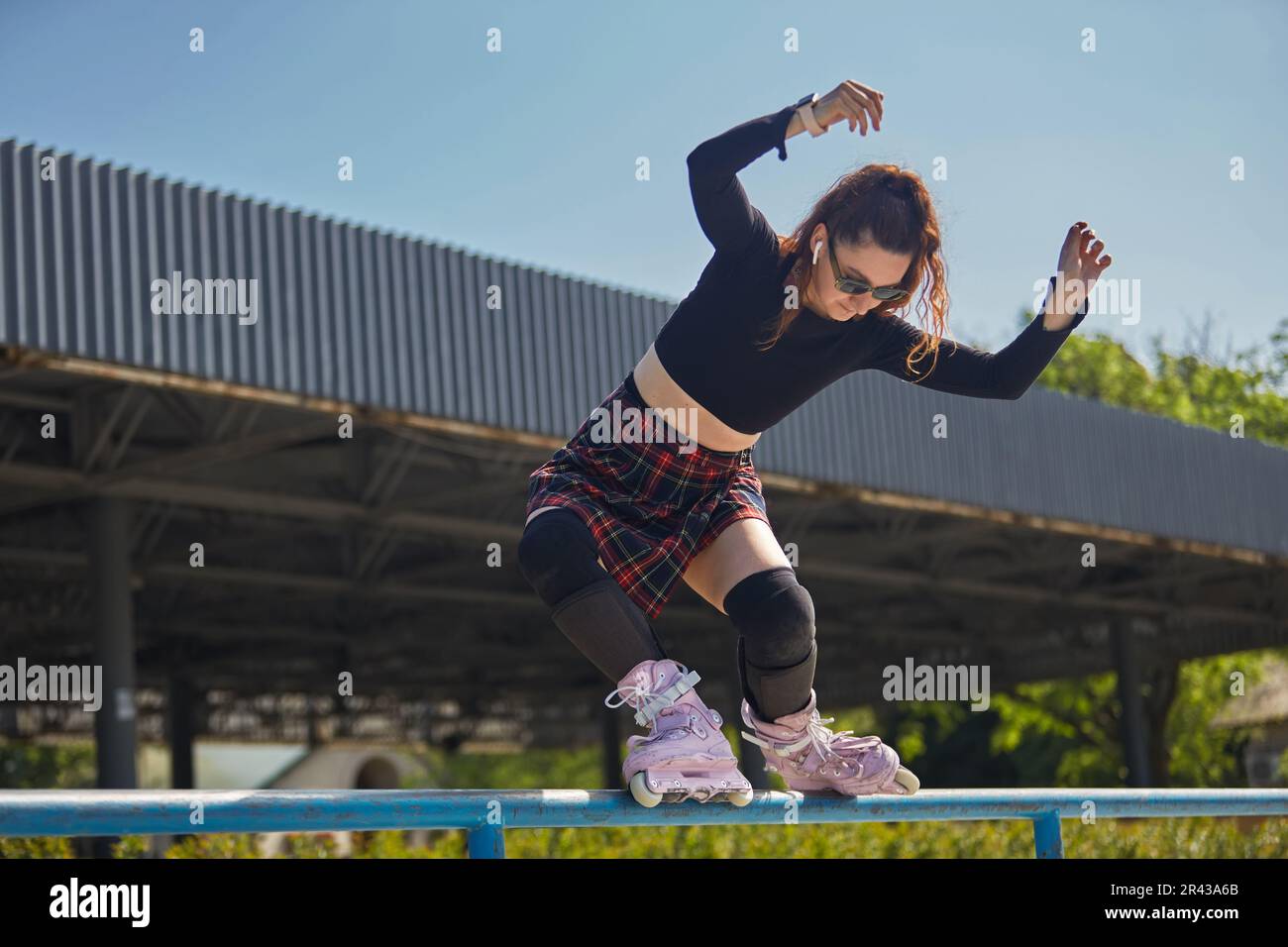 Inline roller blader female performing a miszou grind trick on a