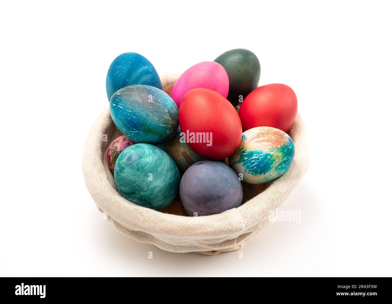 Multi colors Easter eggs in the woven basket isolated on white ...